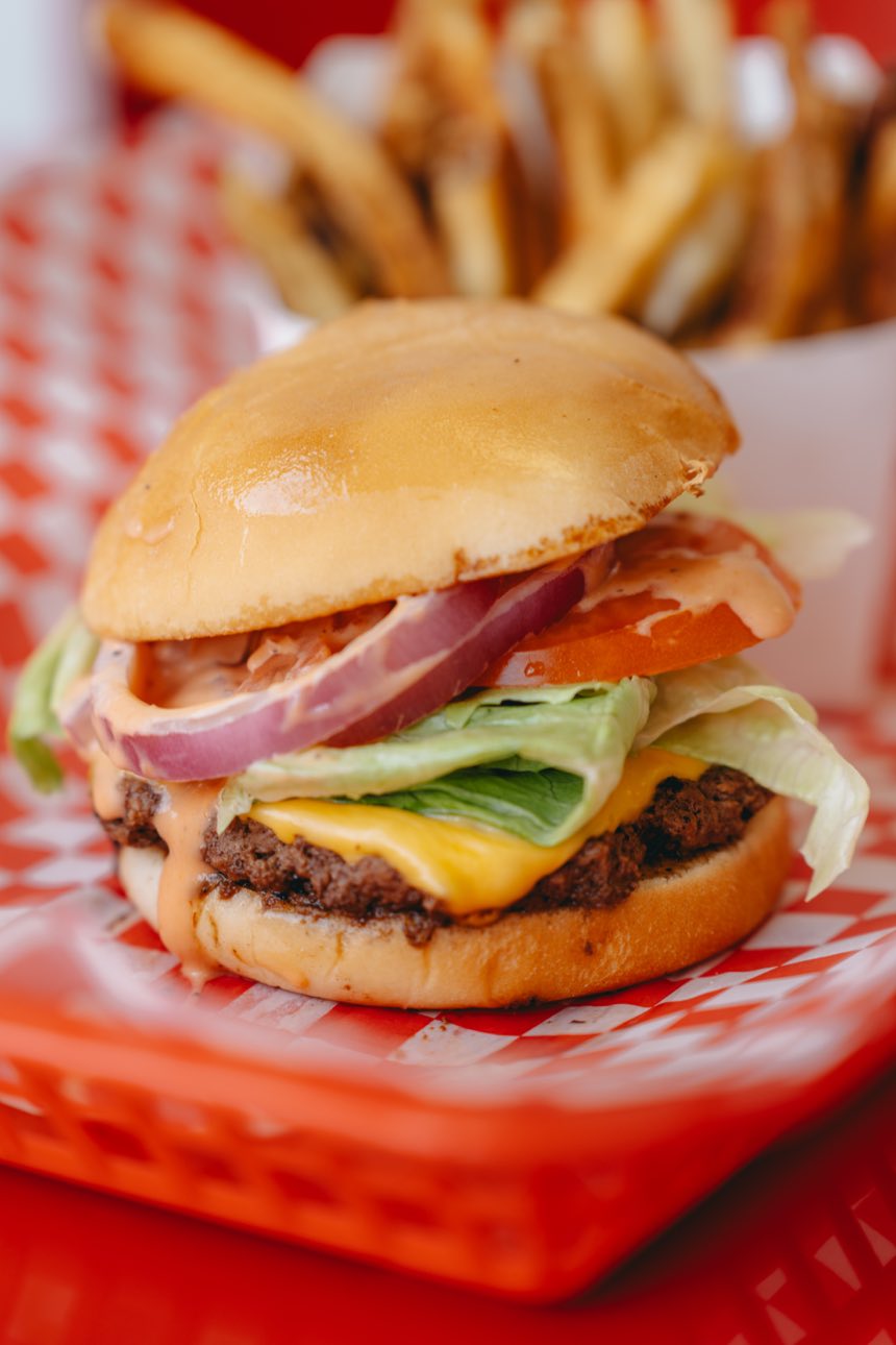 Et Al cheeseburger with lettuce, tomato, onion and Et Al sauce